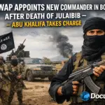 AI generated illustrations Of New ISWAP commander Abu Khalifa holding rifle in front of fighters and pickup truck, Borno conflict zone, DocuNews watermark."