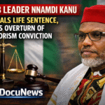 AI generated illustrations Of Nnamdi Kanu, leader of IPOB, seated with a gavel and scales of justice in the background, discussing his appeal against a life sentence.