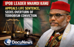 AI generated illustrations Of Nnamdi Kanu, leader of IPOB, seated with a gavel and scales of justice in the background, discussing his appeal against a life sentence.